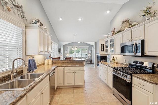 1361 Pinnacle Pines Ct, Bettendorf, IA 52722 - kitchen with appliances with stainless steel finishes, a sink, lofted ceiling, a peninsula, and light tile patterned flooring