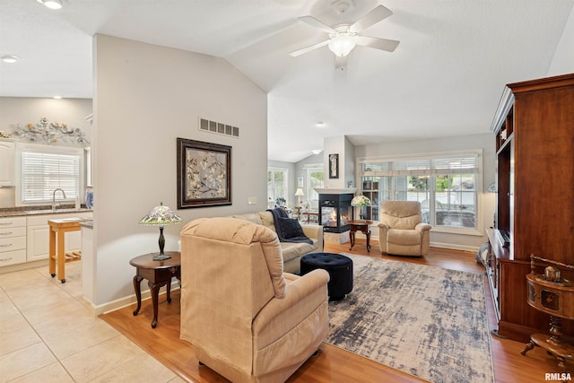 1361 Pinnacle Pines Ct, Bettendorf, IA 52722 - living room with lofted ceiling, ceiling fan, light wood-style flooring, and baseboards