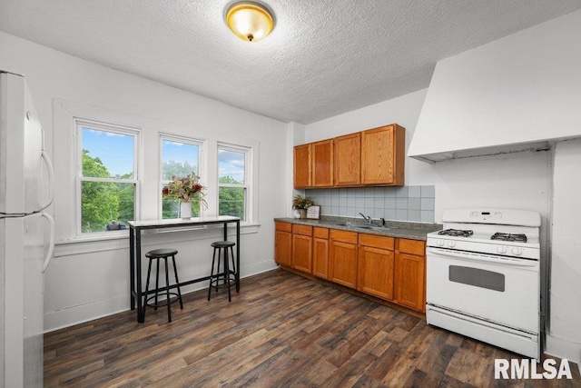 1603 Judson St, Davenport, IA 52803 - kitchen featuring white appliances, brown cabinetry, dark wood-style floors, a textured ceiling, and a sink