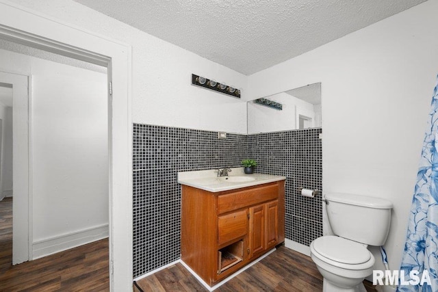 1603 Judson St, Davenport, IA 52803 - full bath with wood finished floors, vanity, tile walls, toilet, and wainscoting