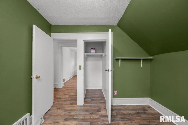1603 Judson St, Davenport, IA 52803 - unfurnished bedroom featuring wood finished floors, lofted ceiling, baseboards, and a textured ceiling