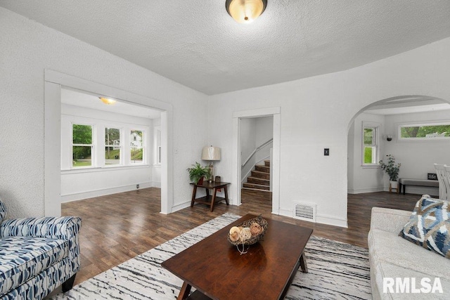 1603 Judson St, Davenport, IA 52803 - living room featuring arched walkways, wood finished floors, stairway, a textured ceiling, and baseboards