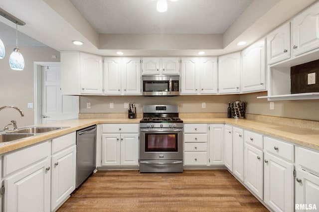 1816 Calico Rd, Marion, IL 62959 - kitchen featuring appliances with stainless steel finishes, white cabinetry, recessed lighting, decorative light fixtures, and light wood-type flooring
