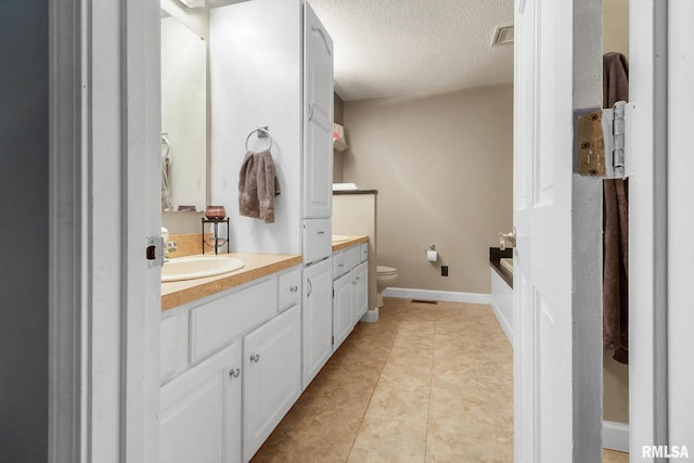 1816 Calico Rd, Marion, IL 62959 - full bath featuring vanity, a textured ceiling, toilet, a tub to relax in, and tile patterned flooring