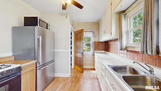 506 18th Ave, Moline, IL 61265 - kitchen with a sink, range with gas stovetop, light wood-style flooring, light countertops, and ceiling fan