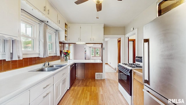 506 18th Ave, Moline, IL 61265 - kitchen featuring appliances with stainless steel finishes, light countertops, light wood-type flooring, a sink, and white cabinetry