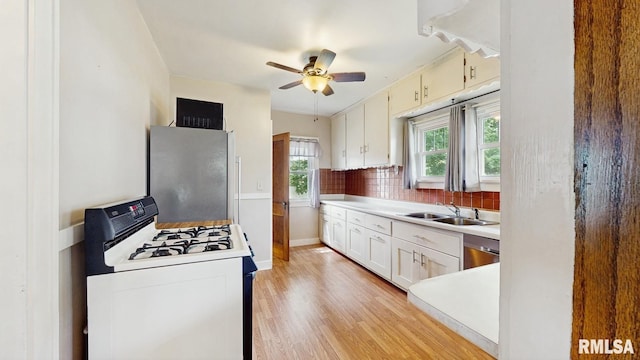 506 18th Ave, Moline, IL 61265 - kitchen with stainless steel appliances, a sink, ceiling fan, light wood finished floors, and light countertops