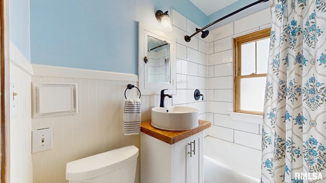 506 18th Ave, Moline, IL 61265 - full bath featuring shower / bath combo with shower curtain, toilet, vanity, and a wainscoted wall