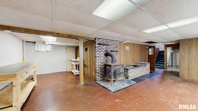 506 18th Ave, Moline, IL 61265 - bar featuring tile patterned floors, a wood stove, a paneled ceiling, stairs, and wooden walls