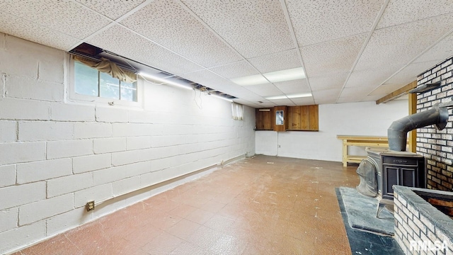 506 18th Ave, Moline, IL 61265 - below grade area featuring a paneled ceiling, a wood stove, and concrete block wall