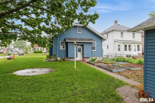 506 18th Ave, Moline, IL 61265 - back of house with a vegetable garden and a yard