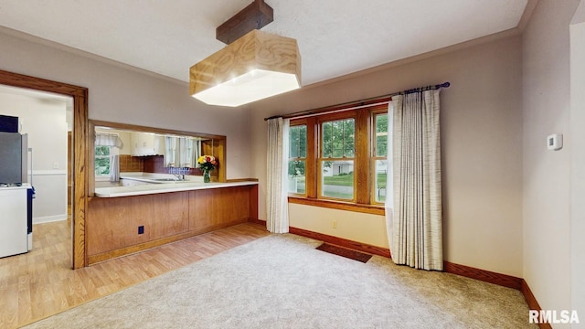 506 18th Ave, Moline, IL 61265 - kitchen featuring baseboards, light carpet, a sink, and light wood finished floors