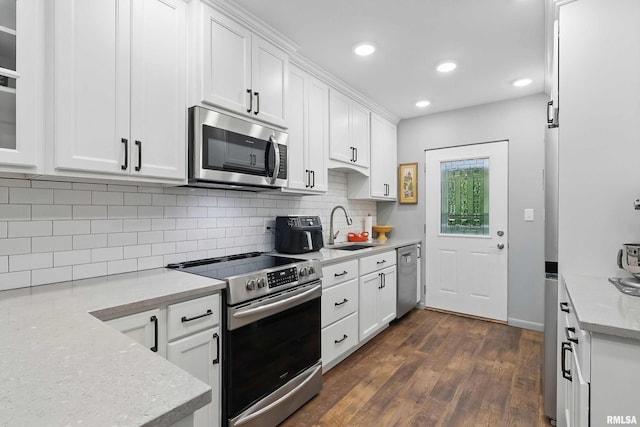 1104 Kimberly Rd Unit 1006, Bettendorf, IA 52722 - kitchen with appliances with stainless steel finishes, a sink, white cabinetry, dark wood-style flooring, and decorative backsplash