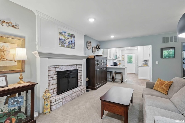 1104 Kimberly Rd Unit 1006, Bettendorf, IA 52722 - living area with a stone fireplace, recessed lighting, and light colored carpet