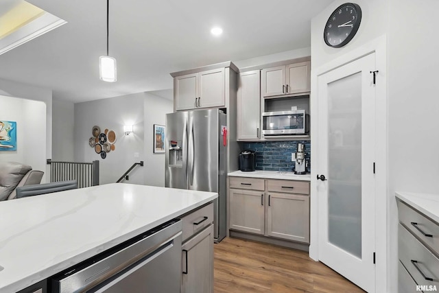 1327 Heights Ct, Bettendorf, IA 52803 - kitchen featuring appliances with stainless steel finishes, tasteful backsplash, wood finished floors, pendant lighting, and gray cabinetry