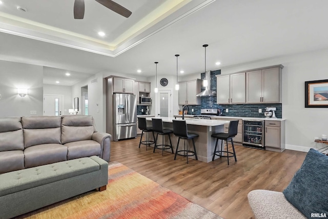 1327 Heights Ct, Bettendorf, IA 52803 - living room with wine cooler, light wood-type flooring, recessed lighting, ceiling fan, and a tray ceiling