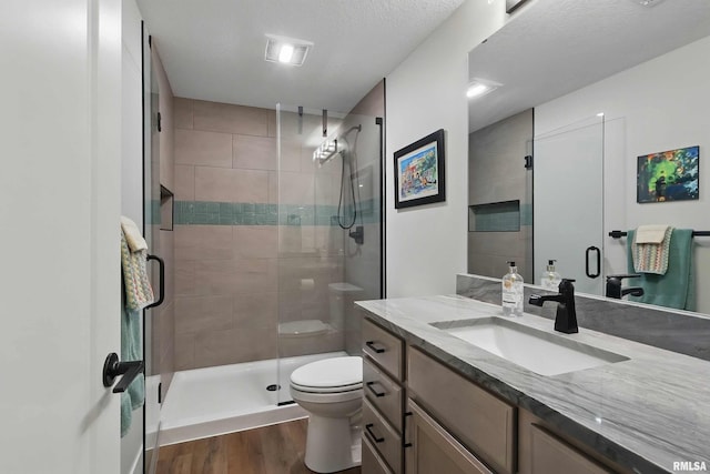 1327 Heights Ct, Bettendorf, IA 52803 - full bath featuring toilet, vanity, a stall shower, and wood finished floors
