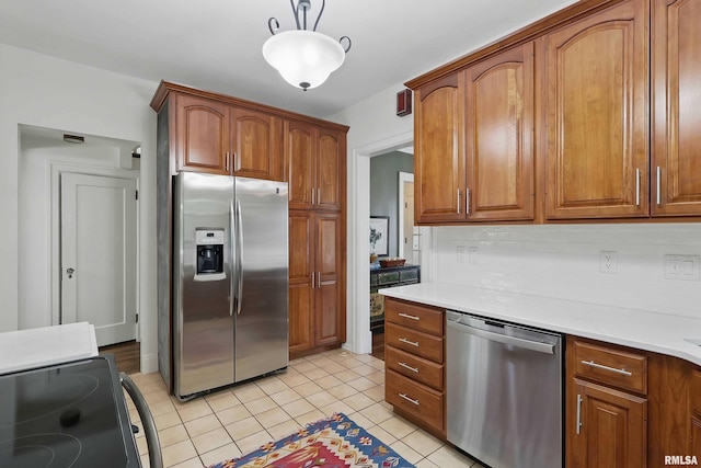 923 22nd St, Moline, IL 61265 - kitchen with stainless steel appliances, brown cabinets, light countertops, and light tile patterned floors