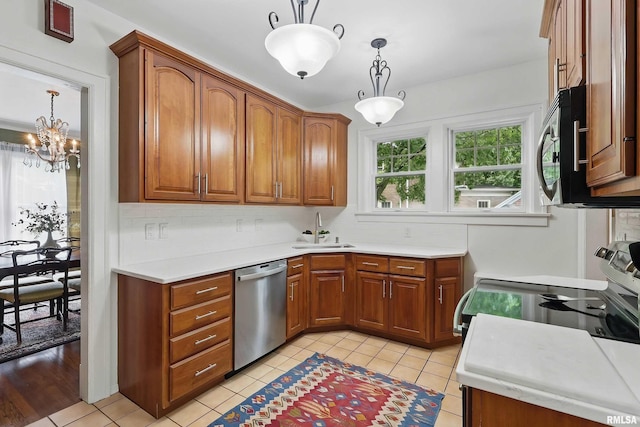 923 22nd St, Moline, IL 61265 - kitchen with appliances with stainless steel finishes, a sink, brown cabinetry, and decorative backsplash