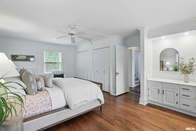 923 22nd St, Moline, IL 61265 - bedroom featuring crown molding, two closets, wood finished floors, and a ceiling fan