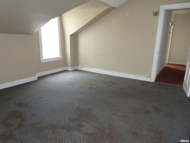 1916 E 13th St, Davenport, IA 52803 - additional living space with dark carpet, lofted ceiling, and baseboards