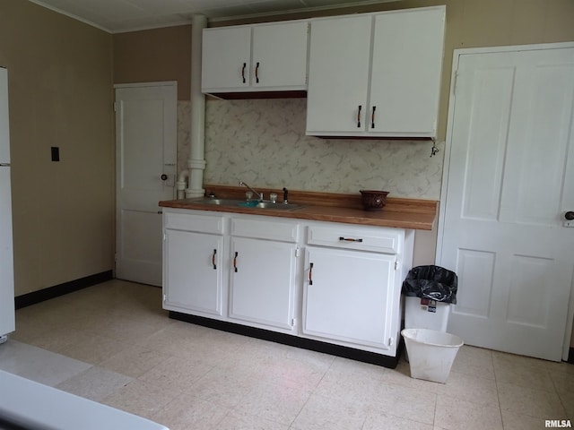 1916 E 13th St, Davenport, IA 52803 - kitchen with a sink, white cabinets, butcher block countertops, and baseboards