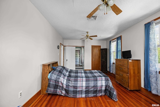 503 SW 4th Ave, Galva, IL 61434 - bedroom featuring wood finished floors, multiple windows, a textured ceiling, and a ceiling fan