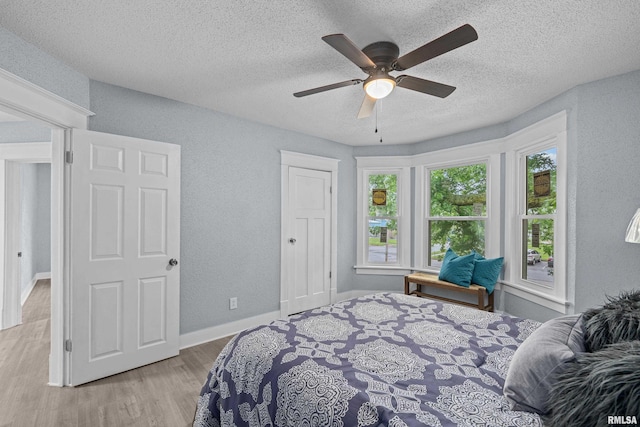 1312 Ripley St, Davenport, IA 52803 - bedroom featuring a textured ceiling, a textured wall, wood finished floors, a ceiling fan, and baseboards