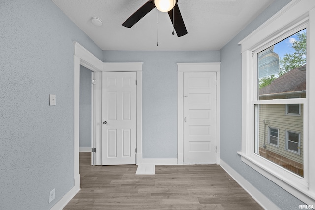 1312 Ripley St, Davenport, IA 52803 - unfurnished bedroom with wood finished floors, baseboards, and ceiling fan