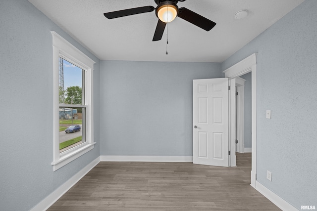 1312 Ripley St, Davenport, IA 52803 - empty room with a ceiling fan, wood finished floors, baseboards, and a textured wall