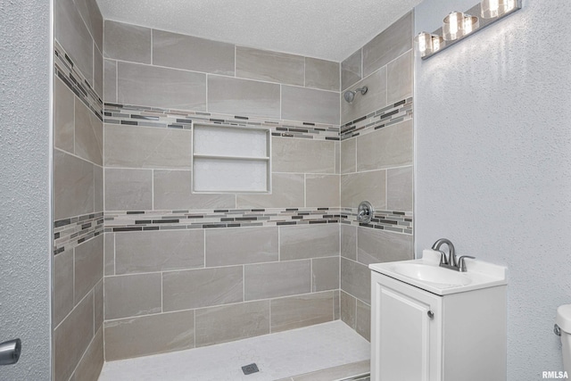 1312 Ripley St, Davenport, IA 52803 - bathroom featuring tiled shower, vanity, toilet, and a textured wall
