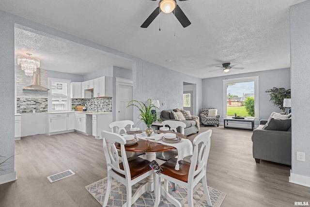1312 Ripley St, Davenport, IA 52803 - dining space featuring a ceiling fan, a textured ceiling, light wood-style floors, and a chandelier