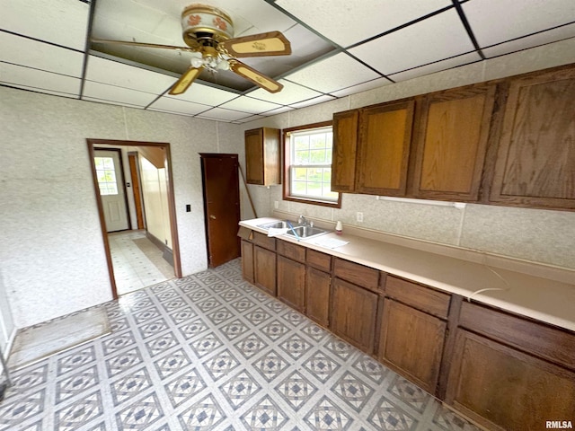 116 W 13th St, Kewanee, IL 61443 - kitchen with light countertops, brown cabinets, a ceiling fan, a sink, and light floors