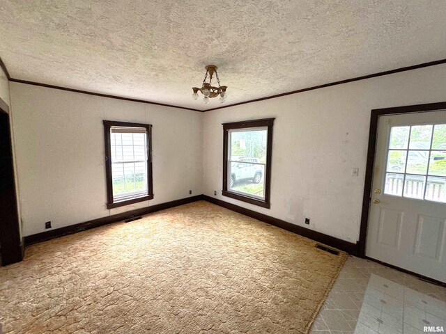 116 W 13th St, Kewanee, IL 61443 - empty room with ornamental molding, a textured ceiling, a chandelier, baseboards, and light colored carpet
