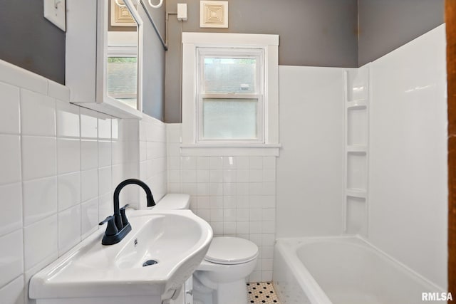 2121 4th St, Moline, IL 61265 - bathroom with tile walls, a sink, toilet, wainscoting, and tile patterned floors
