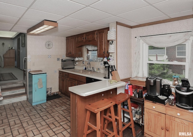 2015 N Zenith Ave, Davenport, IA 52804 - kitchen with a sink, a paneled ceiling, a peninsula, light countertops, and a breakfast bar
