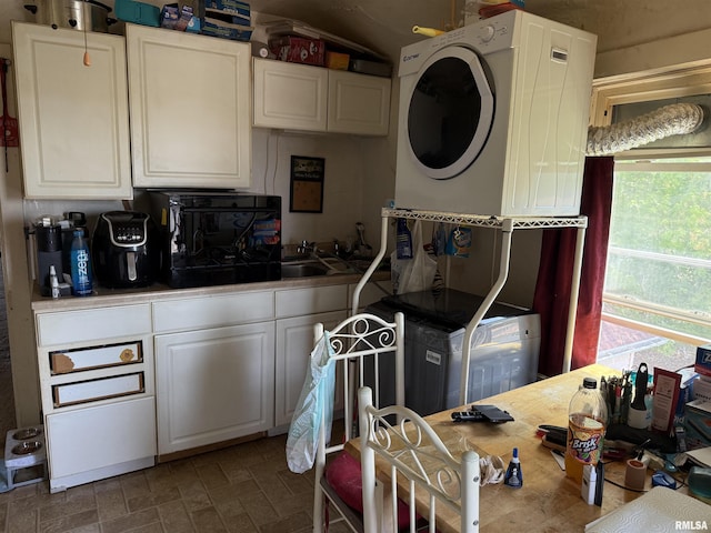 105-109 NE 5th Ave, Aledo, IL 61231 - kitchen with white cabinets, a sink, brick patterned flooring, and stacked washing machine and dryer