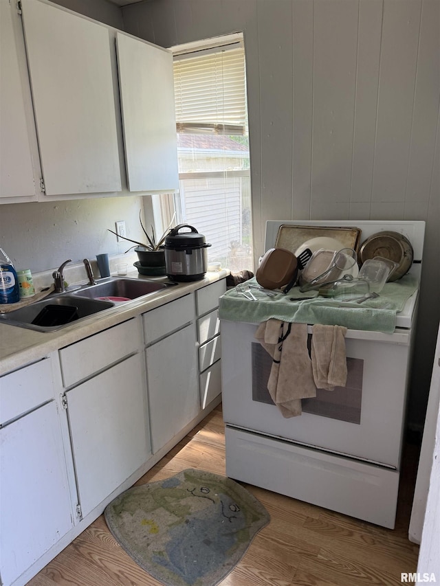 105-109 NE 5th Ave, Aledo, IL 61231 - kitchen with a sink, light countertops, white cabinets, light wood-style floors, and white range with electric cooktop