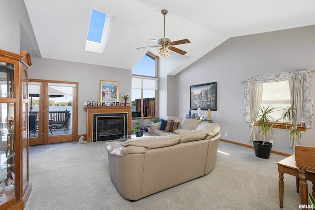 22867 Great River Rd, Le Claire, IA 52753 - living room with carpet floors, a ceiling fan, lofted ceiling, a glass covered fireplace, and a skylight