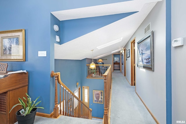 22867 Great River Rd, Le Claire, IA 52753 - hall featuring an upstairs landing, light colored carpet, a skylight, vaulted ceiling, and baseboards