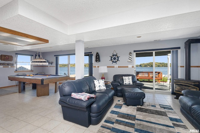 22867 Great River Rd, Le Claire, IA 52753 - tiled living area featuring a textured ceiling, a wood stove, billiards table, and a water view