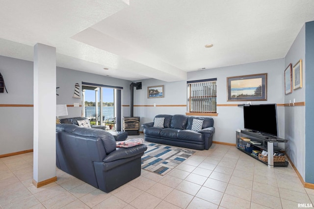 22867 Great River Rd, Le Claire, IA 52753 - living room with baseboards, a wood stove, and light tile patterned flooring