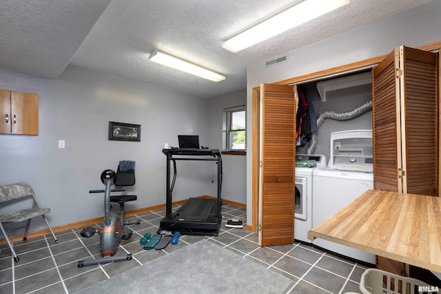 22867 Great River Rd, Le Claire, IA 52753 - workout room featuring washer and clothes dryer, a textured ceiling, and baseboards