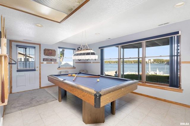 22867 Great River Rd, Le Claire, IA 52753 - rec room with baseboards, a textured ceiling, healthy amount of natural light, a water view, and pool table