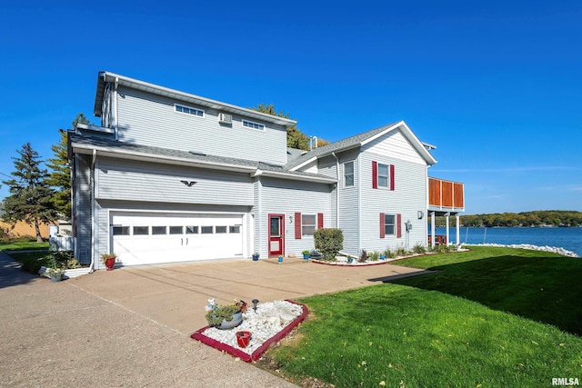 22867 Great River Rd, Le Claire, IA 52753 - traditional home with an attached garage, a front yard, concrete driveway, and a water view