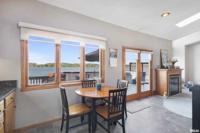 22867 Great River Rd, Le Claire, IA 52753 - dining area featuring a glass covered fireplace and baseboards
