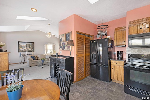 22867 Great River Rd, Le Claire, IA 52753 - kitchen with black appliances, a skylight, ceiling fan, vaulted ceiling, and tasteful backsplash