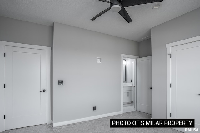 1816 E 59th Ct, Davenport, IA 52807 - unfurnished bedroom with light colored carpet, baseboards, connected bathroom, a textured ceiling, and ceiling fan