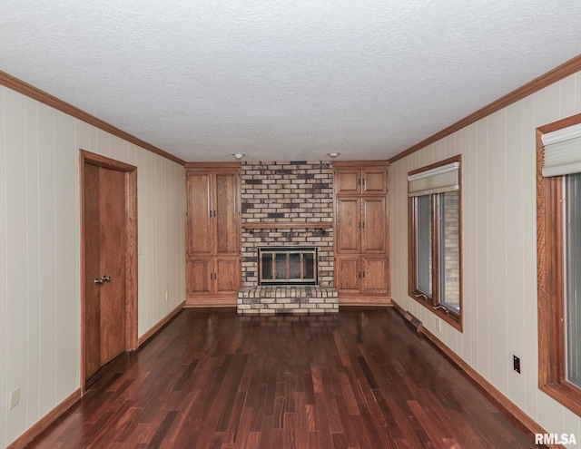 3 Wildwood Trl, Bettendorf, IA 52722 - unfurnished living room featuring dark wood finished floors, a brick fireplace, crown molding, a textured ceiling, and baseboards