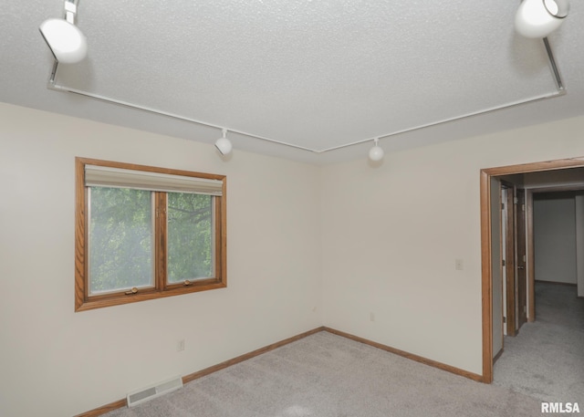 3 Wildwood Trl, Bettendorf, IA 52722 - empty room featuring track lighting, light colored carpet, baseboards, and a textured ceiling